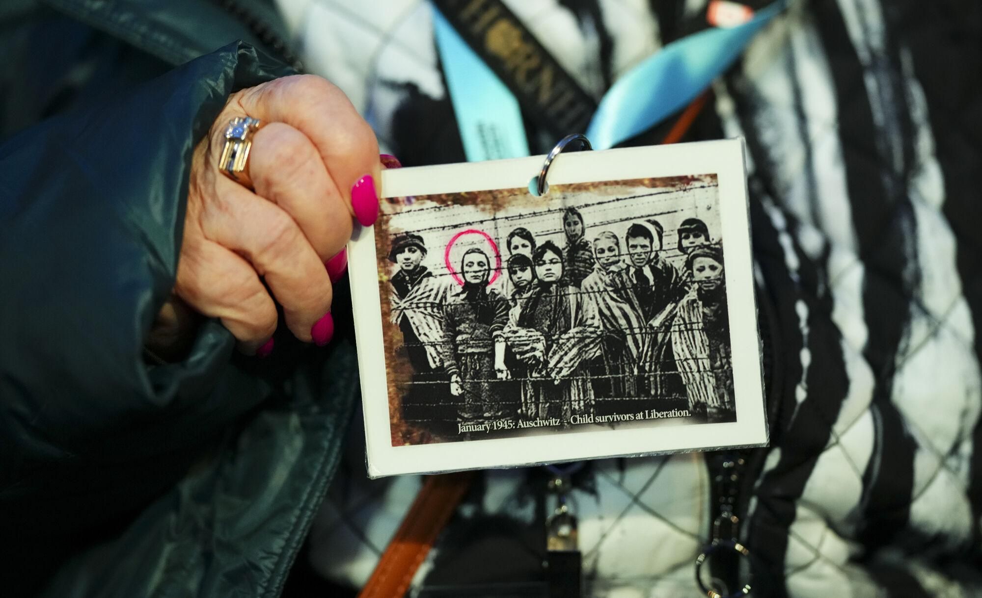 Canadian Holocaust survivor Miriam Ziegler holds up a photo of her (circled) as as she attends the Commemoration Ceremony of the 80th Anniversary of the Liberation of Auschwitz, in Oswiecim, Poland, on Monday, Jan. 27, 2025. (Sean Kilpatrick/The Canadian Press via AP). MANDATORY CREDIT
