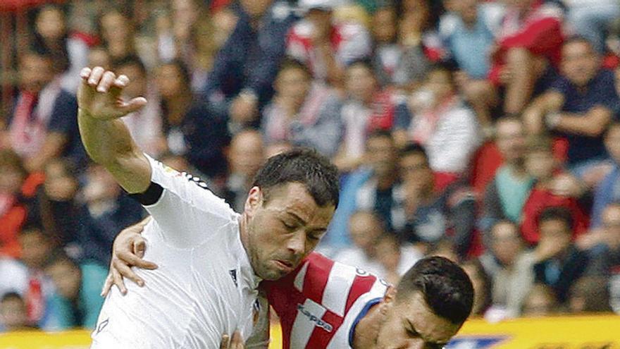 Javi Fuego, en su etapa en el Valencia, disputa un balón con Sergio.