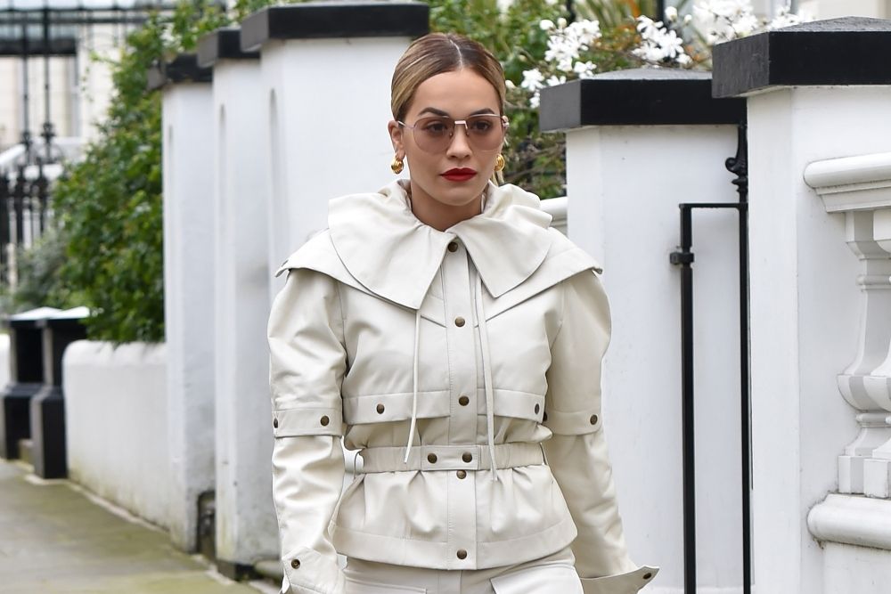 Detalle de la original chaqueta con corchetes, falsa capa y solapas que Rita Ora ha lucido con un pantalón a juego en Notting Hill