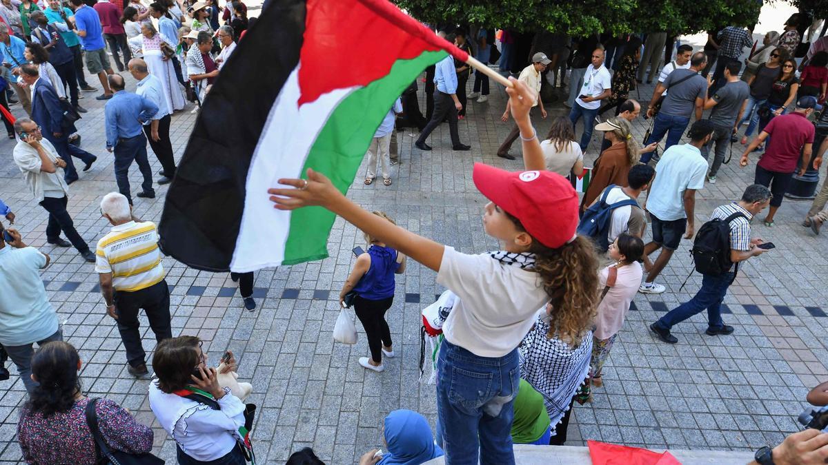 Una niña ondea una bandera de Palestina durante una protesta en Túnez.