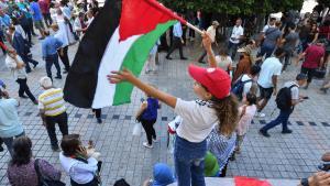 Una niña ondea una bandera de Palestina durante una protesta en Túnez.