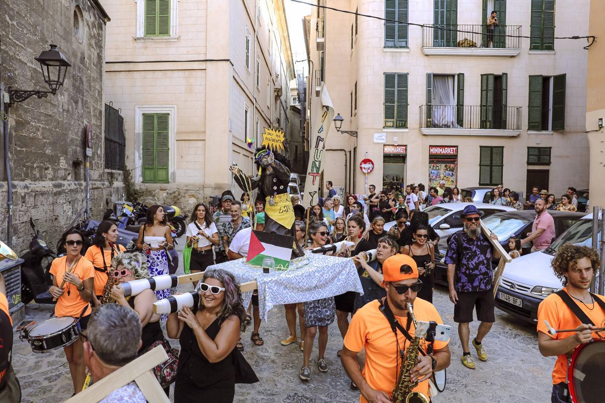 Vecinos de la Calatrava y Canamunt, muchos vestidos de verde y con ramas de árboles, se unen durante sus cercavilas para homenajear a los bellasombras talados en la plaza Llorenç Villalonga.