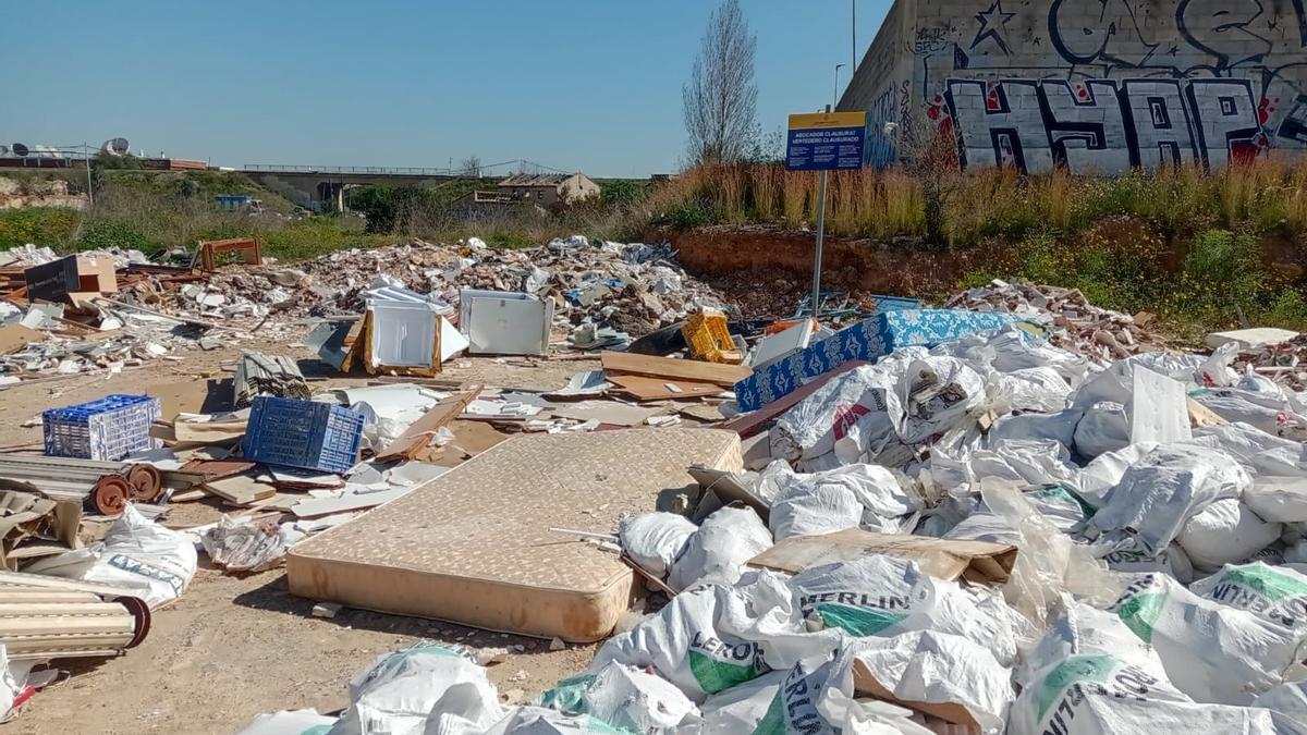 Basura acumulada tras el ecoparque con el cartel de "vertedero clausurado"