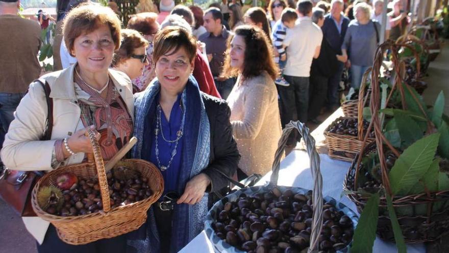 La recolectora Ana María Miranda con sus castañas, acompañada por Raisa Messina.