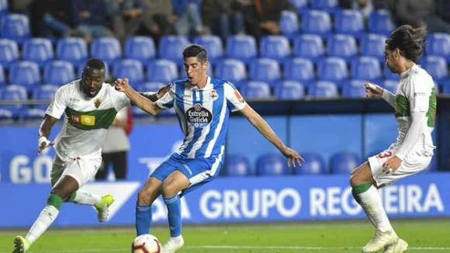 Carlos, en medio de dos defensas en la jugada del segundo gol.