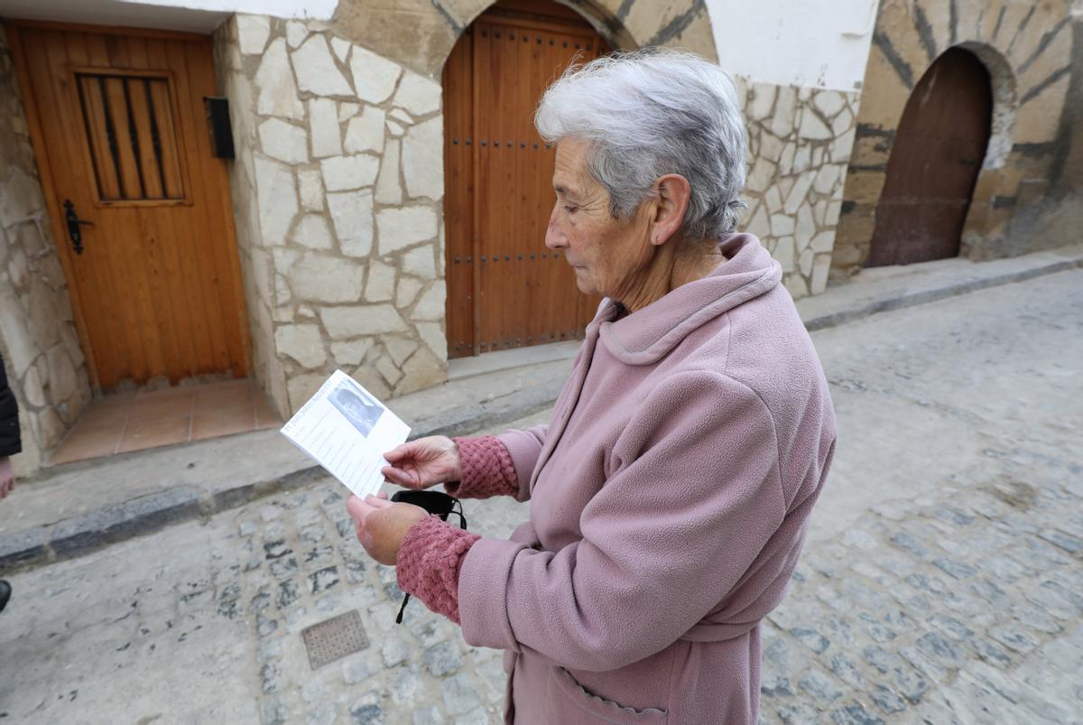 María, que trabajó 30 años en el santuario de San José de Calasanz, examina una foto del padre John, al que no conoció.
