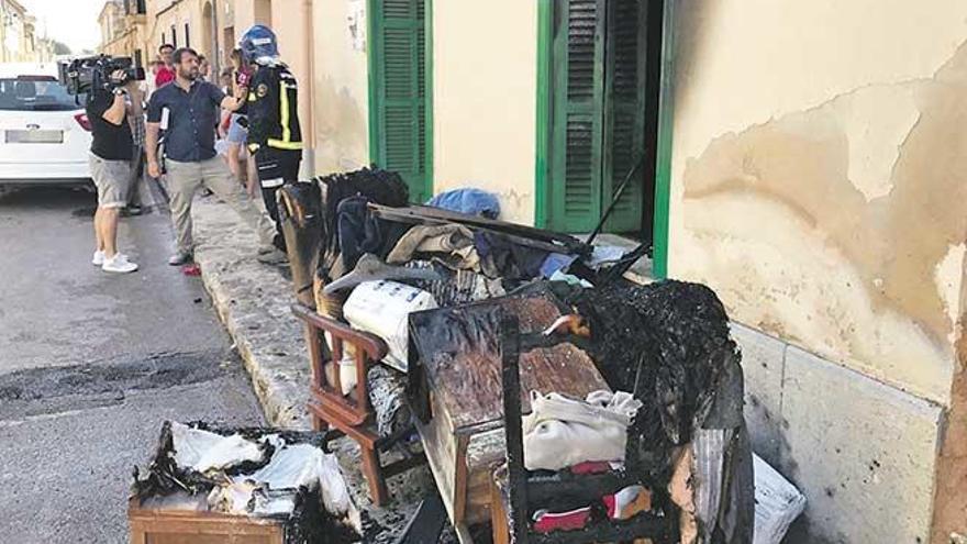 Reporteros de televisión hablan con uno de los bomberos tras el incendio en la vivienda de la calle Baronia de Terrades.