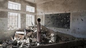 Un niño ante las ruinas de su escuela en Yemen.
