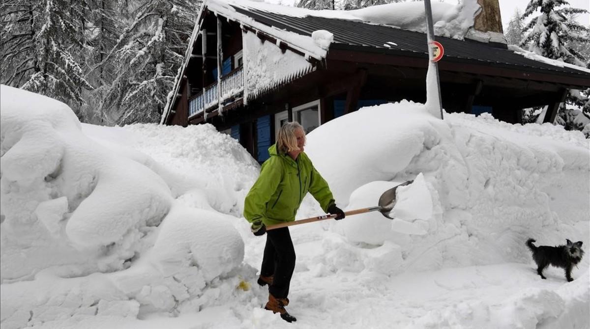 zentauroepp41536575 a woman shovels snow in the village of val d isere  as the p180302154058