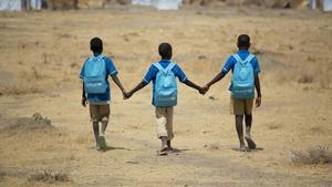 Unos niños africanos se dirigen al colegio. 