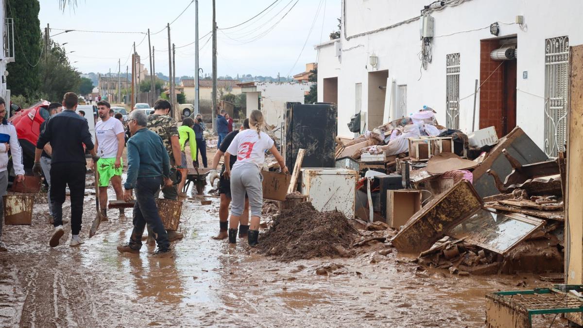 Retirando el barro en el Xenillet, uno de los barrios de Torrent más afectados.