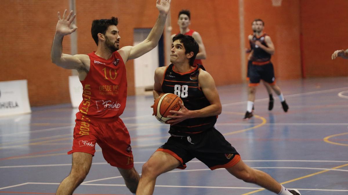 Mario Serrano (Ciudad de Córdoba) controla el balón ante Fernando de Torres (Folder Maristas).