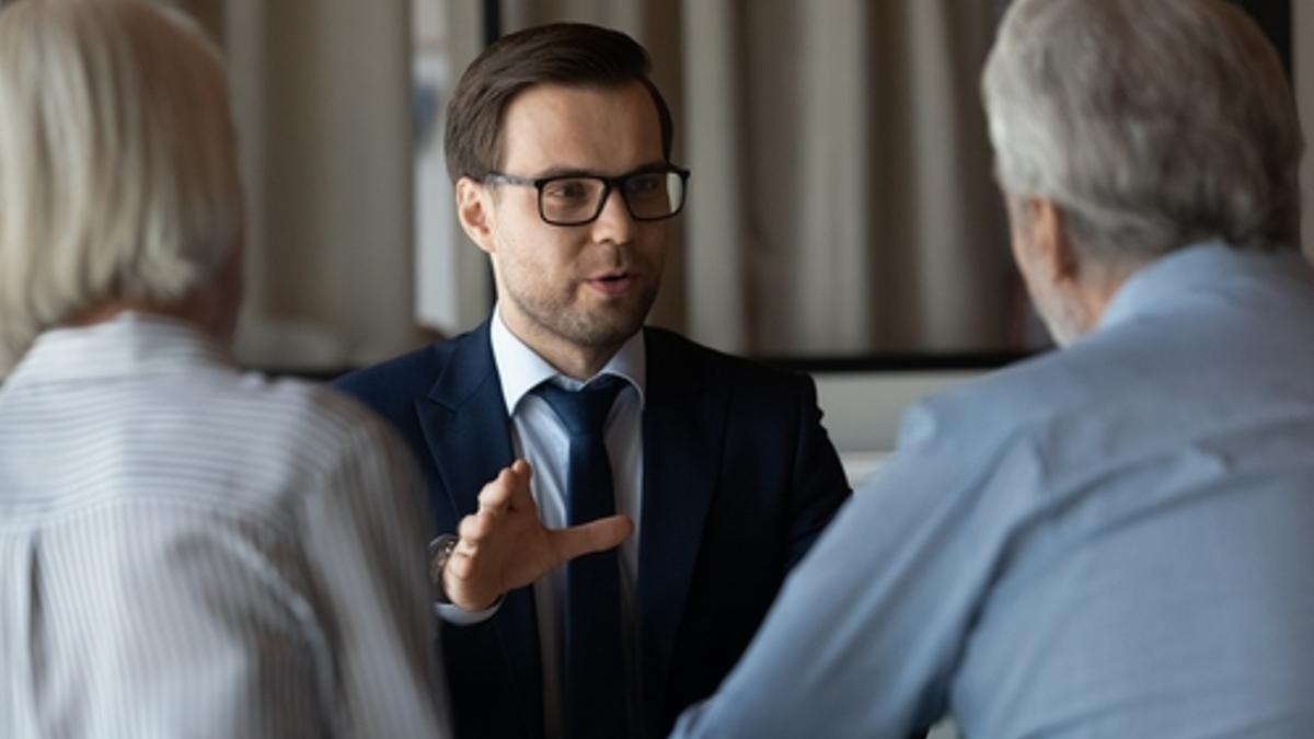 Un experto inmobiliario asesora a una pareja de clientes.