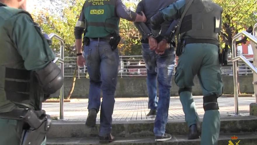 Los agentes se llevan a uno de los 89 detenidos.