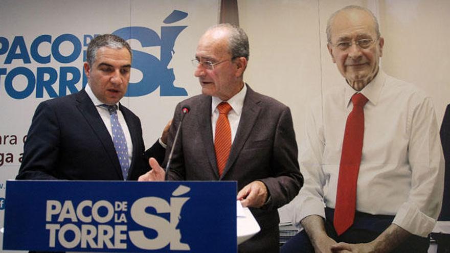 De la Torre con Elías Bendodo, presidente provincial del PP, presentando la lista con el cartel electoral del alcalde de fondo.