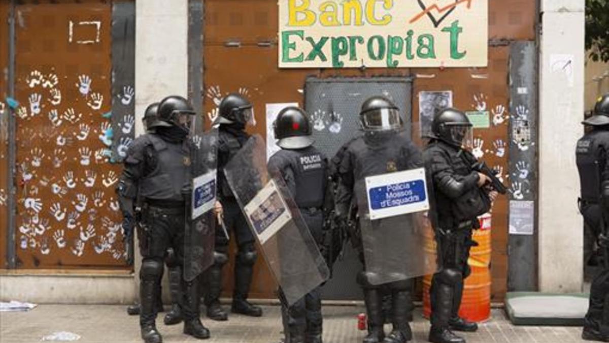 Mossos delante del 'banc expropiat' en Gràcia, el pasado junio.