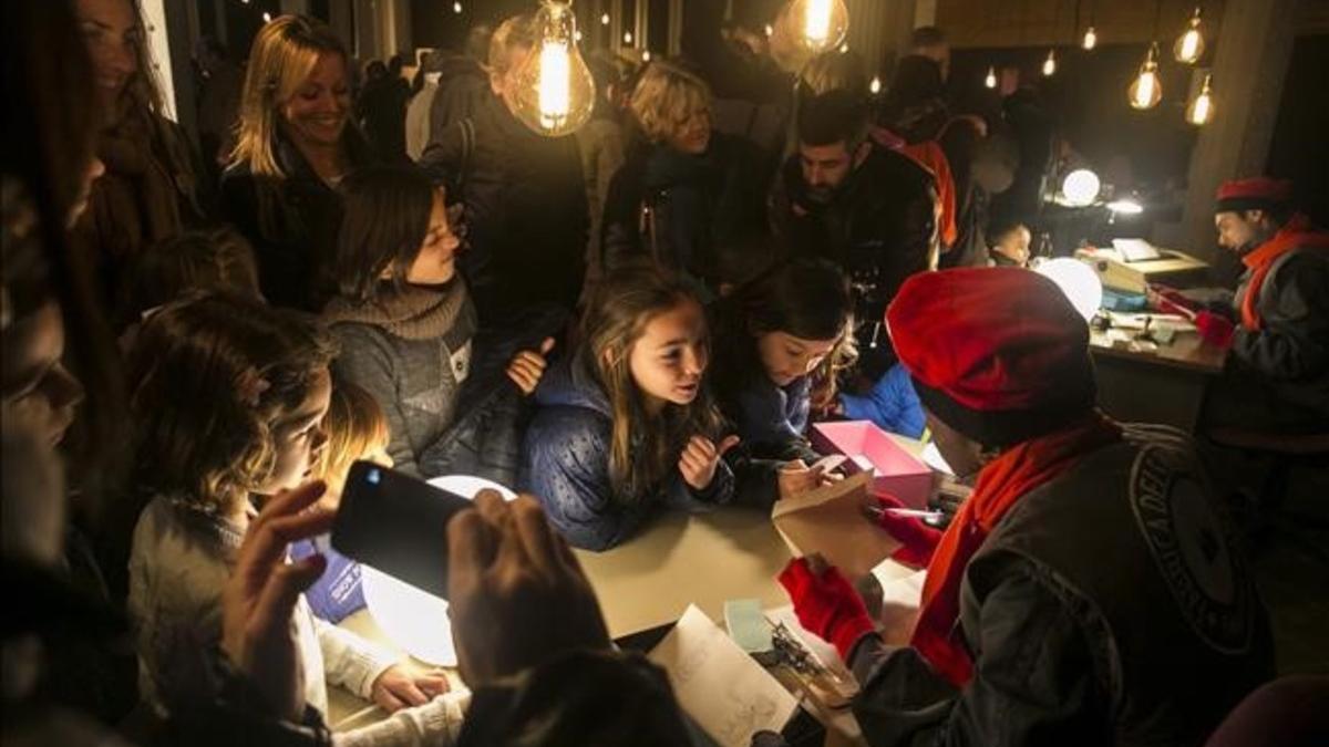 Un duende atiende a dos niñas, el lunes en la Fàbrica del Reis d'Orient.