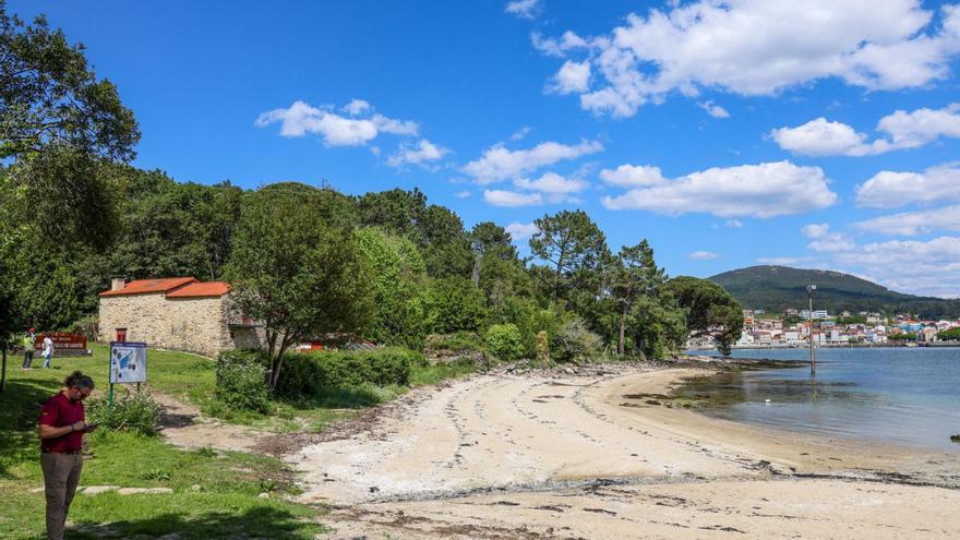 Una playa de la isla de Cortegada, con una construcción de la aldea a la izquierda. | Iñaki Abella