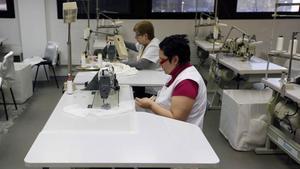 Mujeres trabajando en un taller de confección de vestidos de novia.  