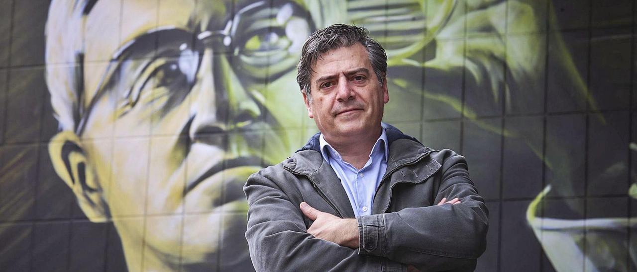 Luis Delgado, junto al mural a la entrada del Instituto Doctor Fleming de Oviedo. |  IRMA COLLÍN