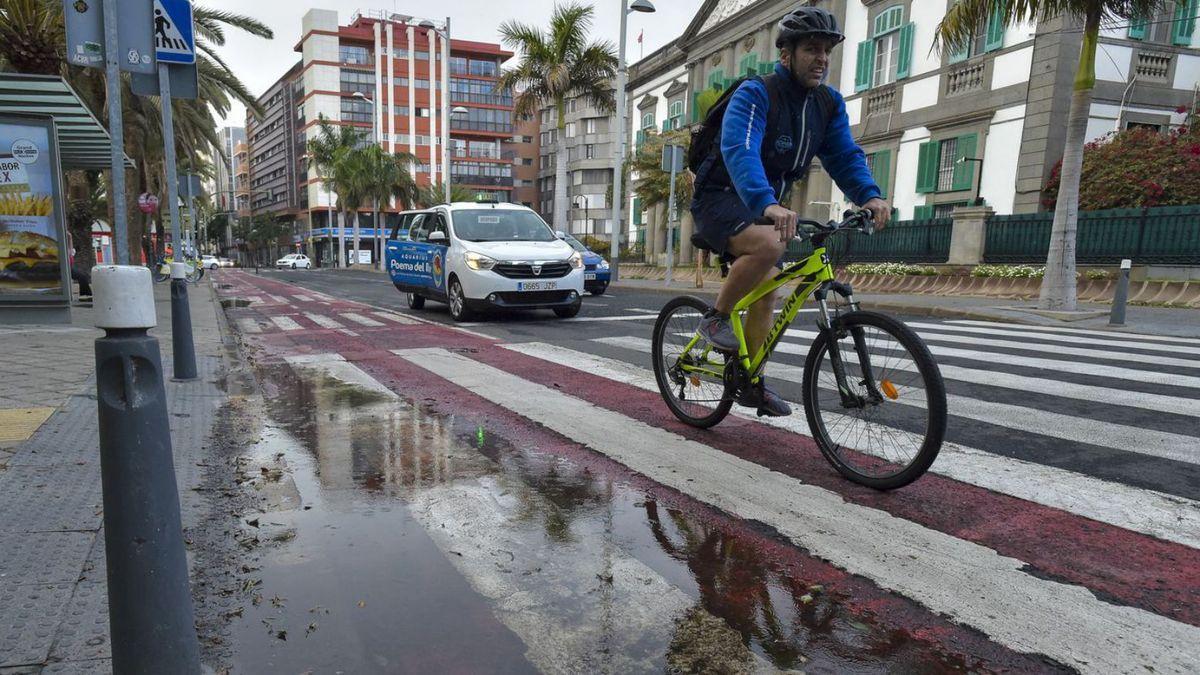 Un ciclista circula por el carril bici en León y Castillo, donde se formaron charcos de agua