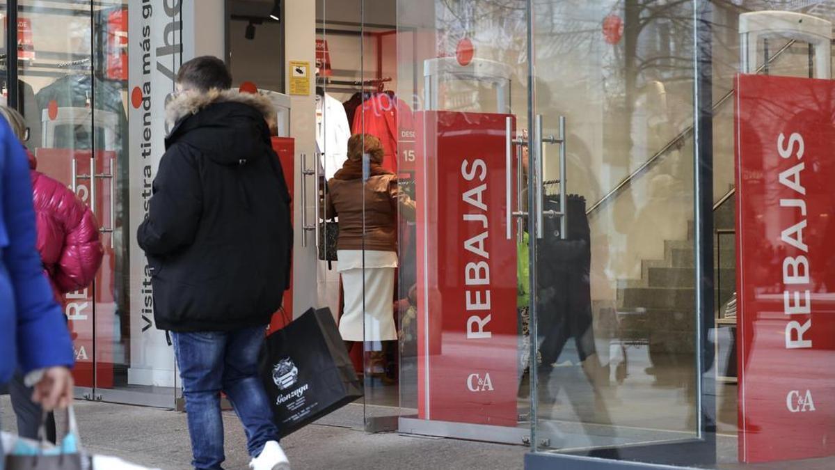 Un joven pasea con una bolsa a las puertas de un comercio en una imagen de archivo.