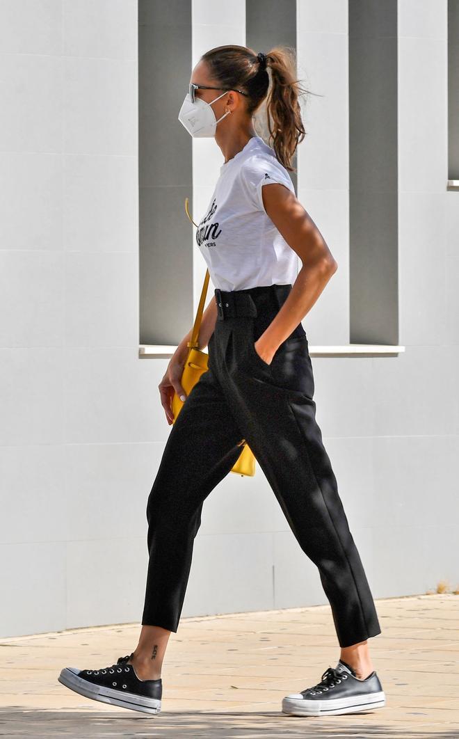 Eva González con camiseta blanca, pantalón negro y zapatillas Converse