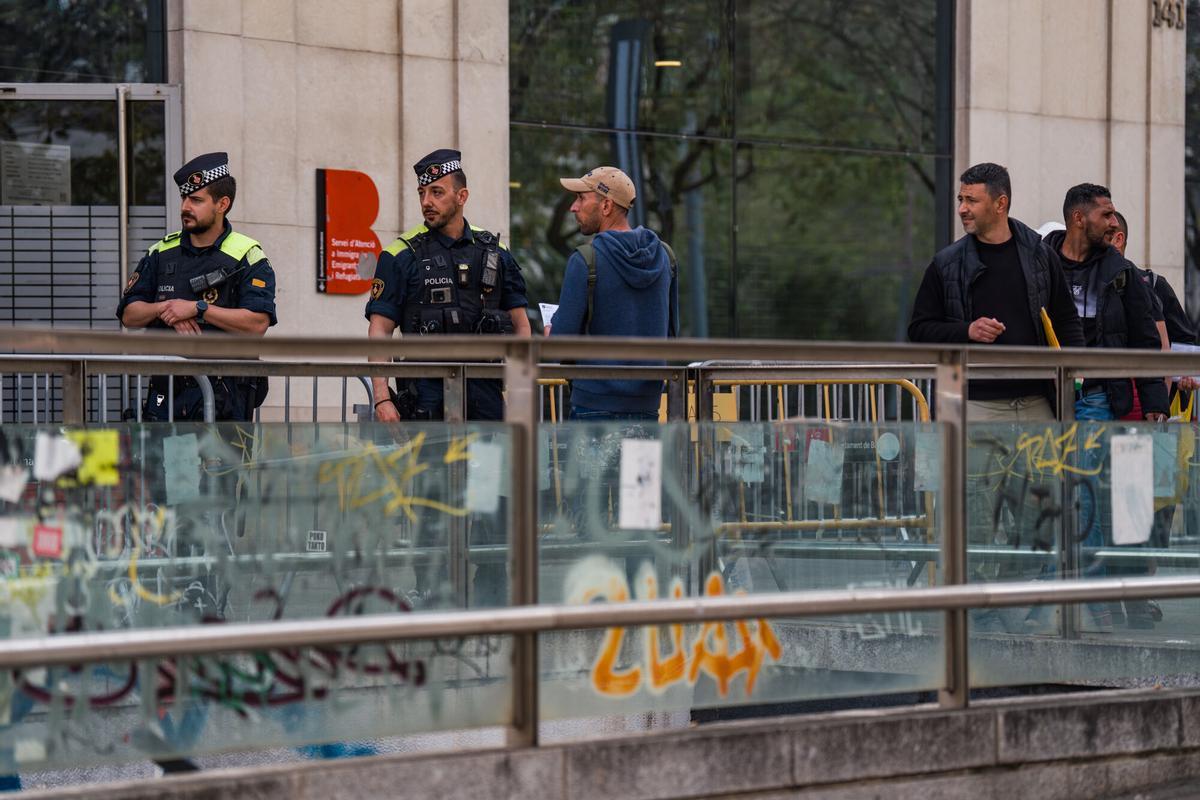 Caos y una larga cola de personas que esperan regularizar su situación en España en la Oficina de Benestar Social i Família de Barcelona-Sants/Eixample.