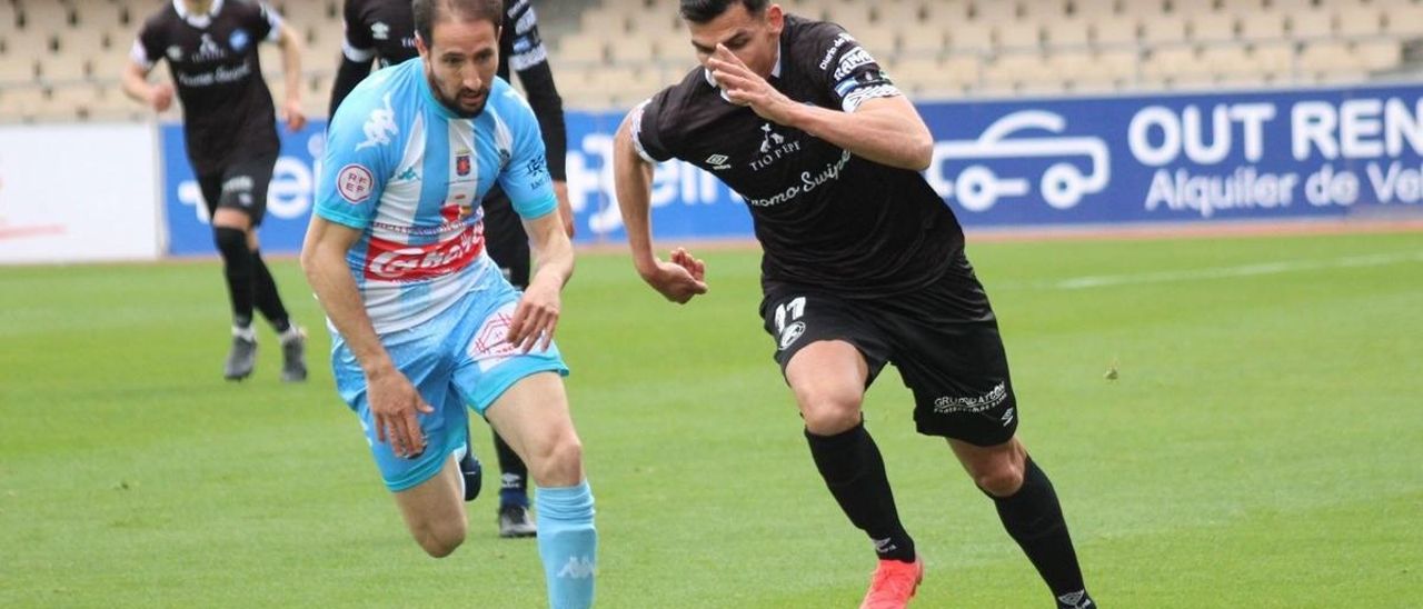 Carlos García corre tras el balón junto a un jugador del Xerez.