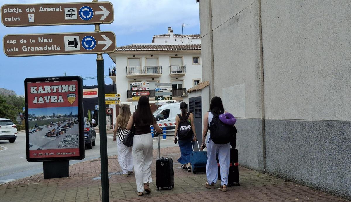 Jóvenes turistas con la maleta a rastras buscando el apartamento de alquiler