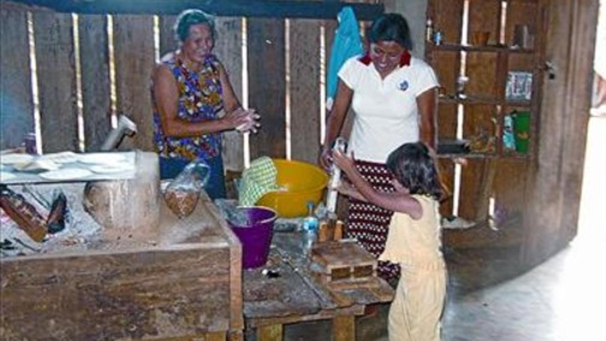 Imelda y dos de sus hijas, haciendo tortas.