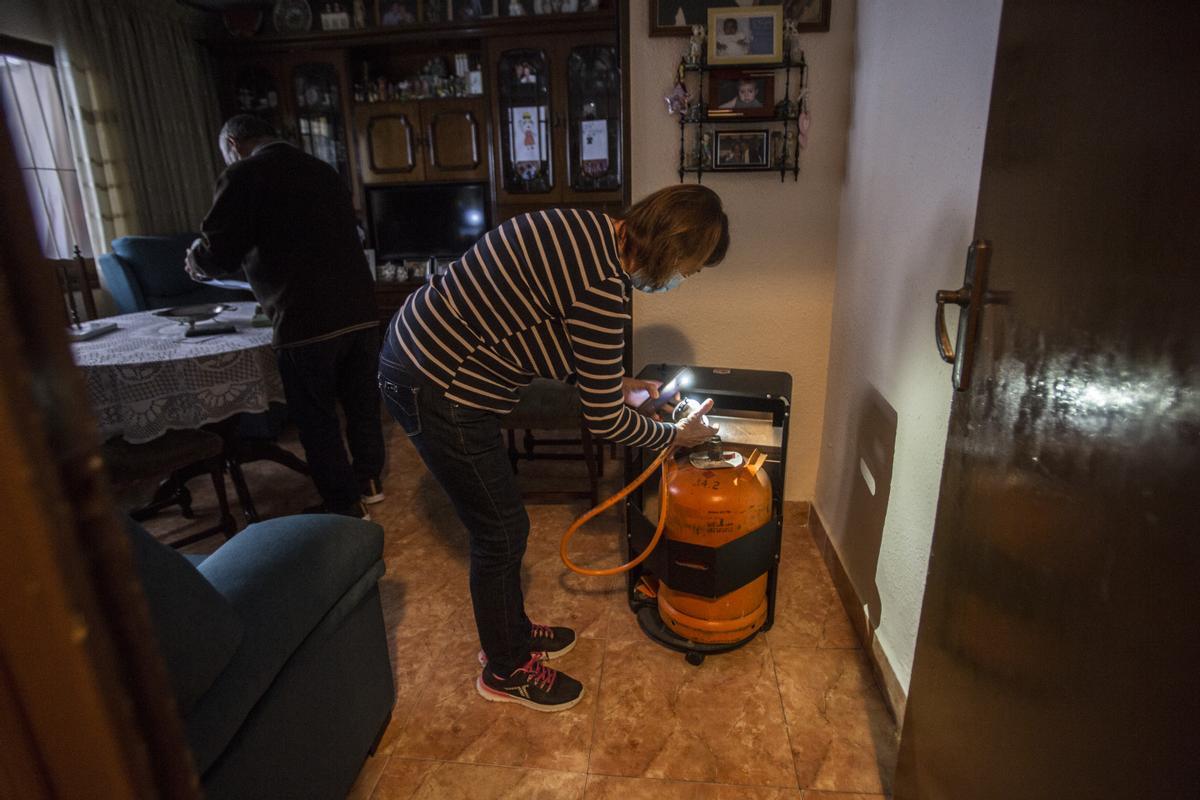 Una mujer coloca una botella de butano en su vivienda de Alicante.