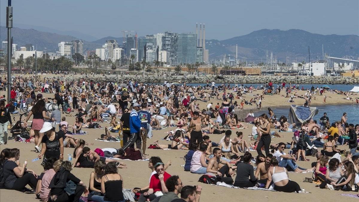 Las altas temperaturas han llenado la playa de la Barceloneta.
