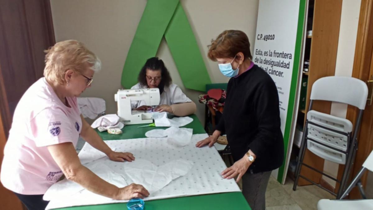 Tres mujeres en uno de los talleres de corazones solidarios de la AECC de Benavente. / E. P.