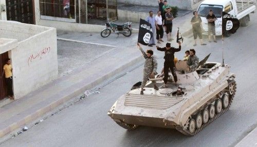 Combatientes islamistas militantes participan en un desfile militar por las calles de la provincia norteña de Raqqa de Siria.