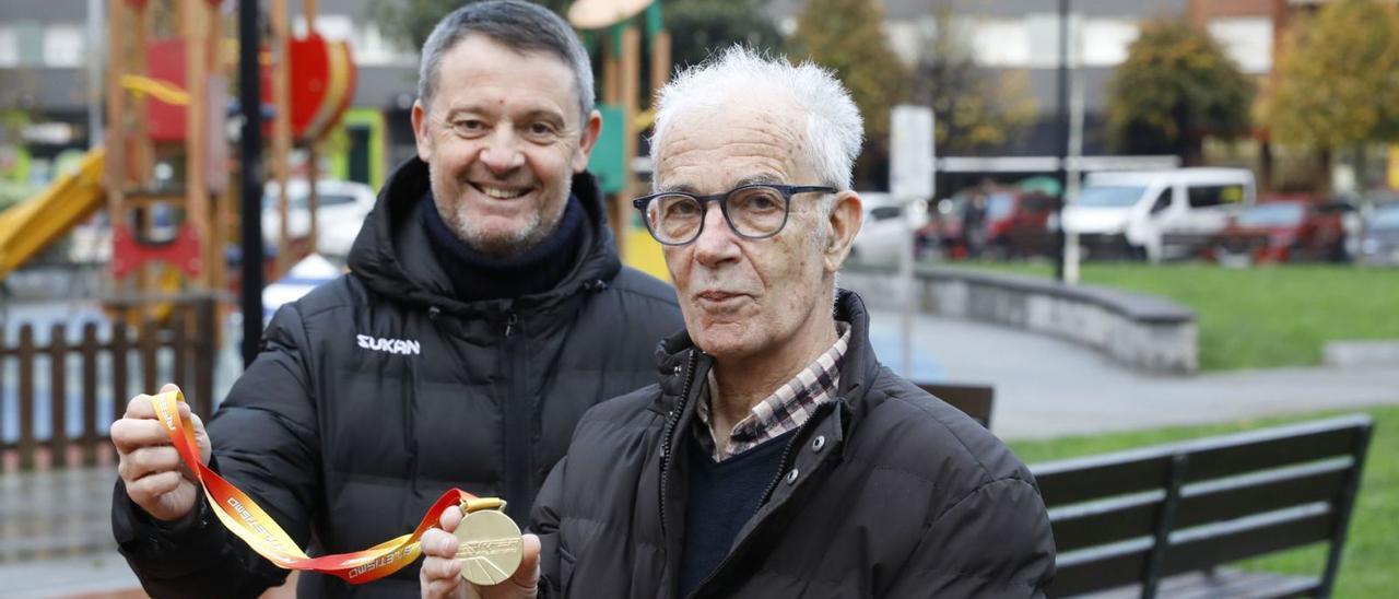 José María Sierra, junto a su hijo Fernando, muestra la medalla de oro lograda en el Campeonato de España, ayer, en el Llano. | Marcos León