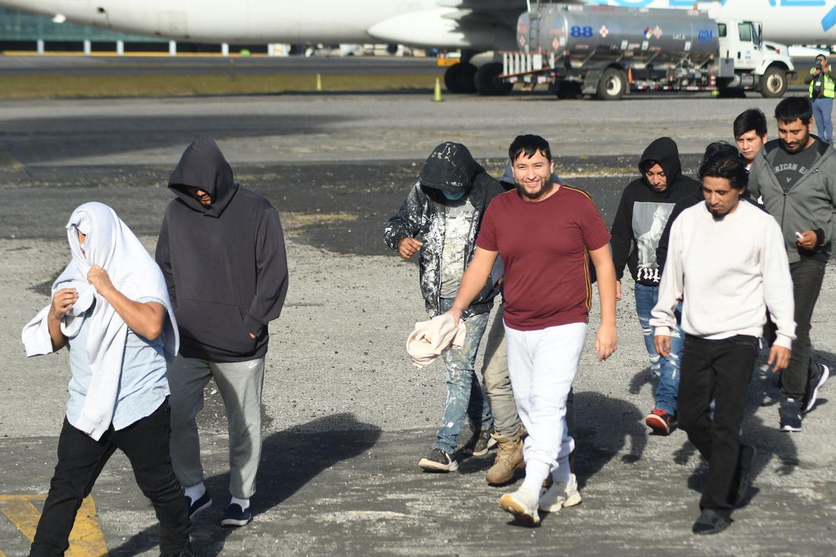 Personas caminan en la base de la Fuerza Aérea Guatemalteca (FAG) luego de la llegada del último vuelo de ciudadanos deportados procedentes de Estados Unidos.