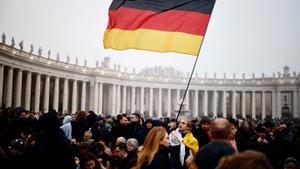 Un hombre alza una bandera alemana en El Vaticano.
