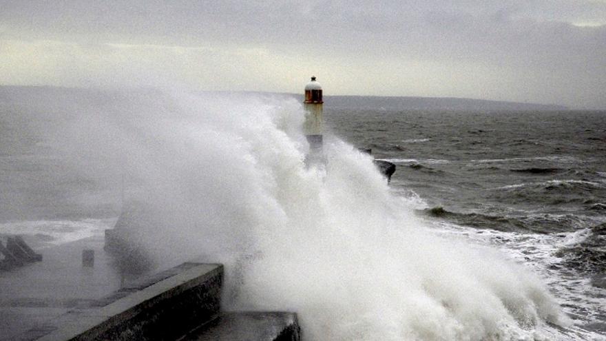 Grandes olas rompen contra un faro y un dique en Porthcawl, Gales (Inglaterra), hoy 10 de marzo de 2008 por los fuertes vientos (de hasta 130 kilómetros por hora) registrados en muchos puntos de las islas británicas.