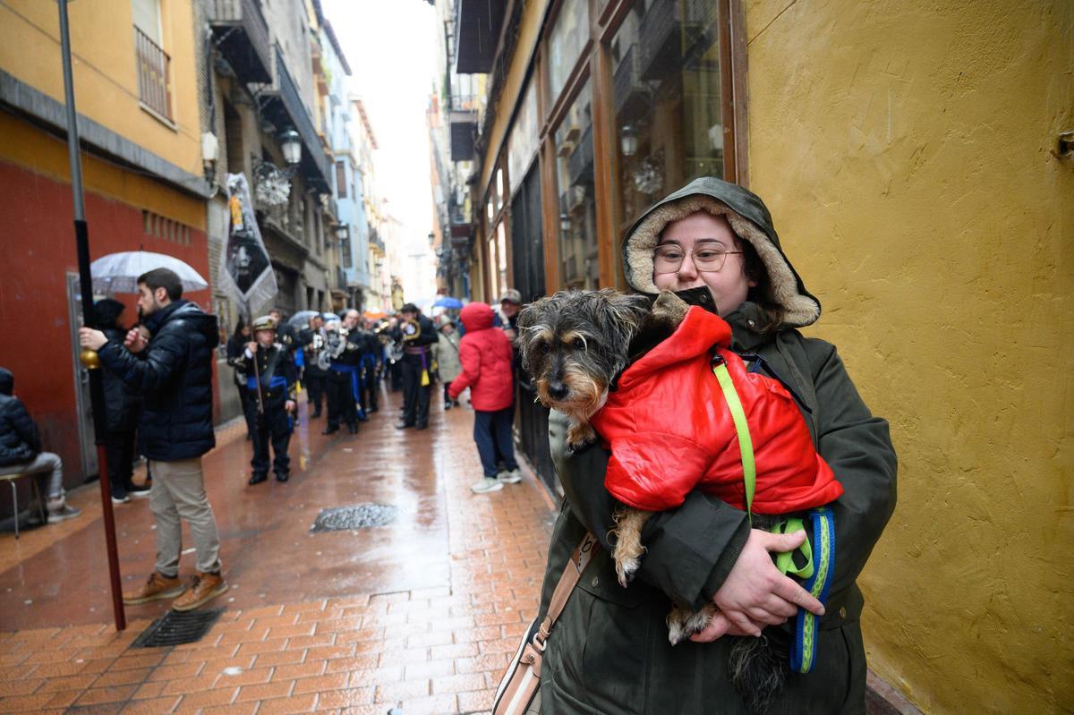 Una tutora camina con su perro en brazos durante la procesión.