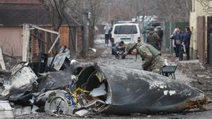 Un soldado mira a los restos de un avión militar ruso derribado durante la noche en Kiev, Ucrania. 