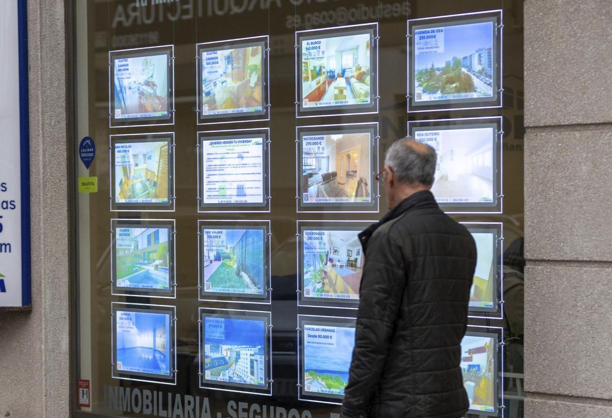 Un hombre camina ante el escaparate de una inmobiliaria en A Coruña. |  G. Barreiros / Roller Agencia