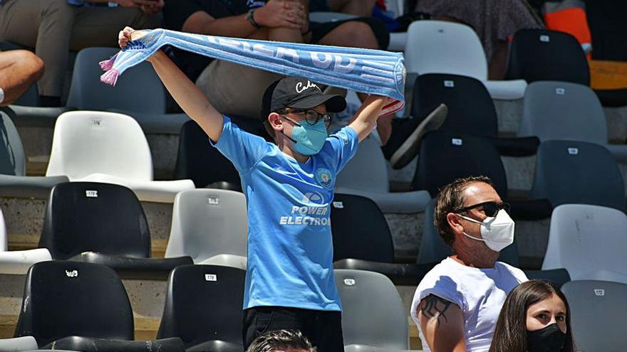Un niño aficionado de la UD Ibiza muestra su bufanda. 