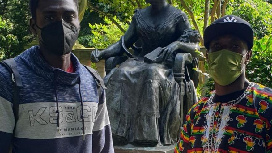 Magatte e Ibrahima, frente a la estatua de Emilia Pardo Bazán. | // L.O.