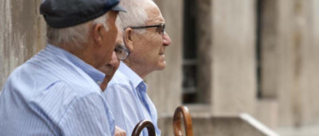 Tres ancianos charlando en una foto de archivo.