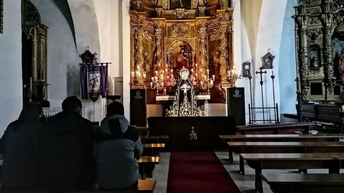 Tres personas veneran a la Virgen de la Soledad, que presidió el altar mayor de Santa Catalina. | M. J. C.