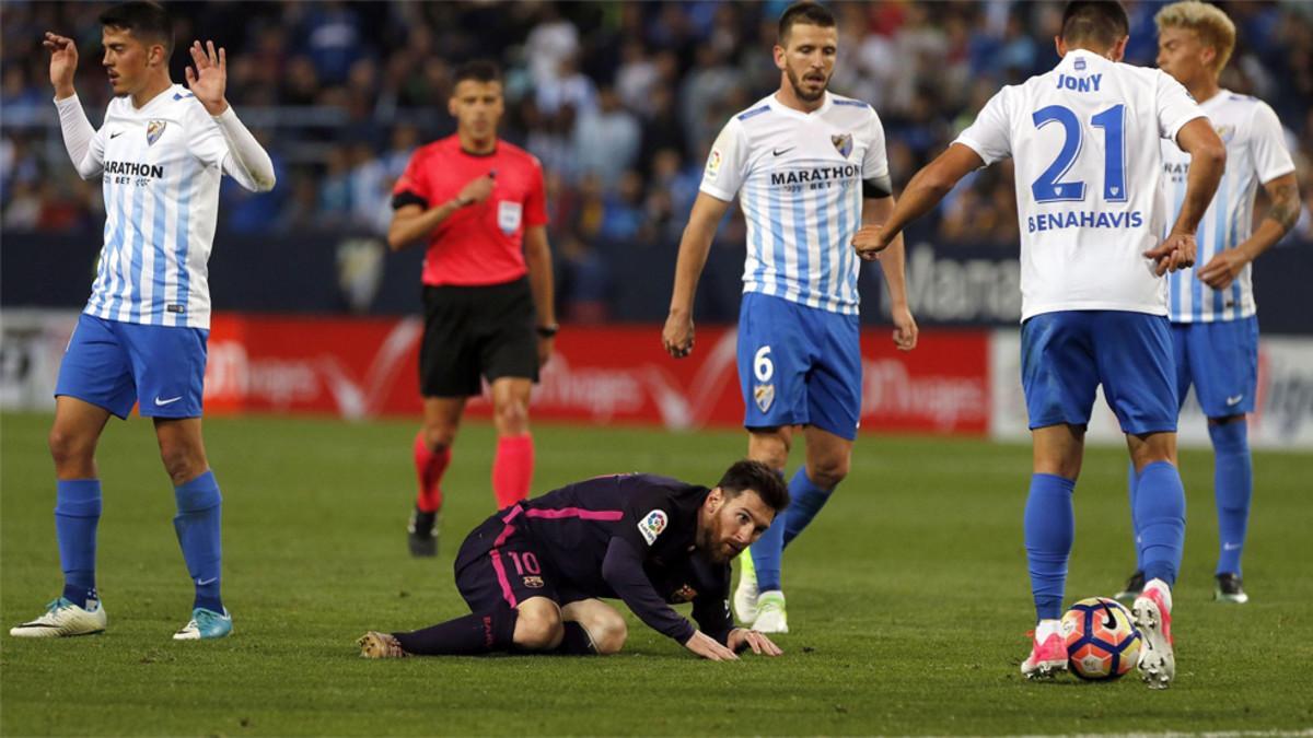 Leo Messi en el suelo, rodeqado de jugadores del Málaga durante el Málaga-Barça de la Liga 2016/17
