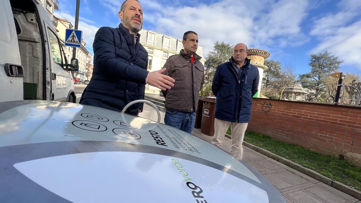 El alcalde, Ángel García, primero por la izquierda, junto al edil Javier Rodríguez y el técnico municipal José Antonio Martínez, junto a uno de los contenedores con la nueva señalética, en el parque de la Pola.