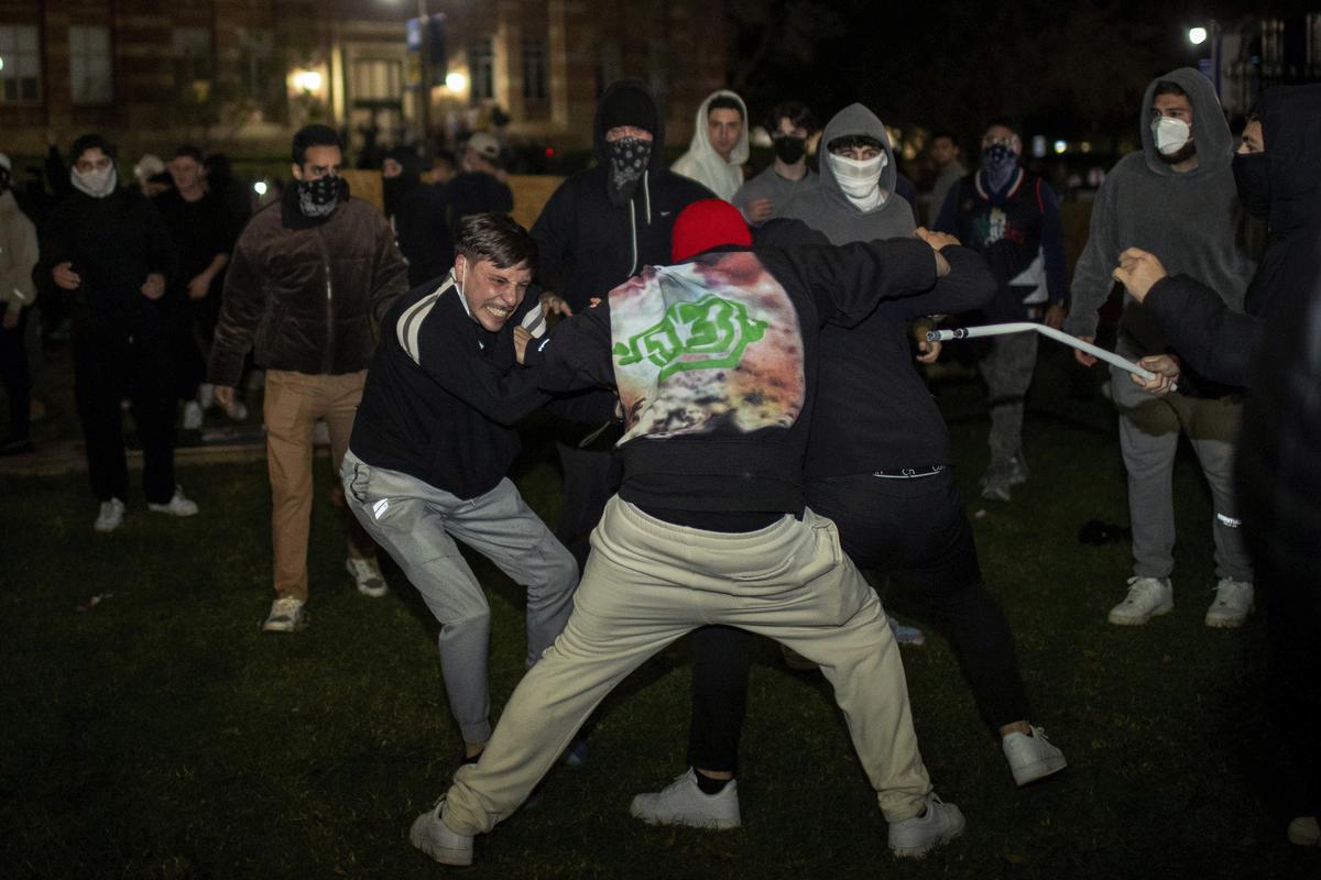 Demonstrators clash at an encampment at UCLA early Wednesday, May 1, 2024, in Los Angeles.  Dueling groups of protesters have clashed at the University of California, Los Angeles, grappling in fistfights and shoving, kicking and using sticks to beat one another. (AP Photo/Ethan Swope) Associated Press / LaPresse Only italy and Spain / EDITORIAL USE ONLY/ONLY ITALY AND SPAIN