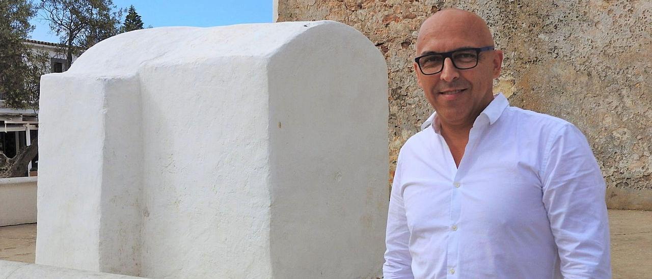 El presidente de los hoteleros de Formentera en Sant Francesc, con la cisterna de la iglesia de fondo. | C.C.